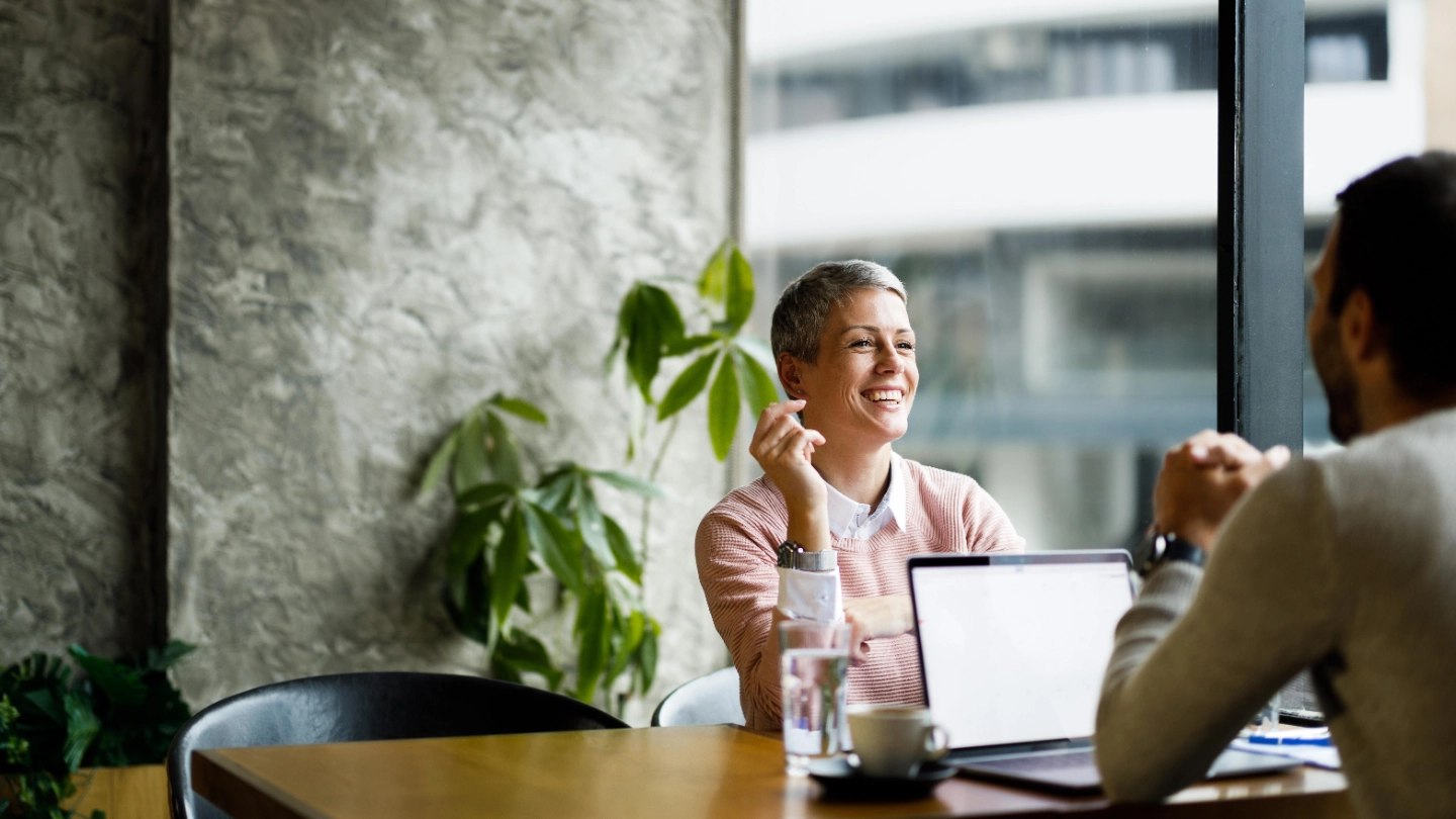 woman and man talking behind laptop right 