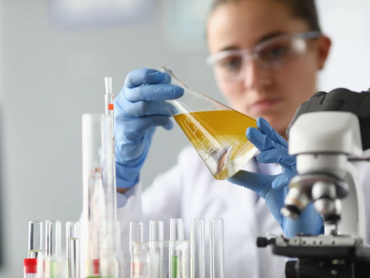 woman chemist scientist holding flask at hand